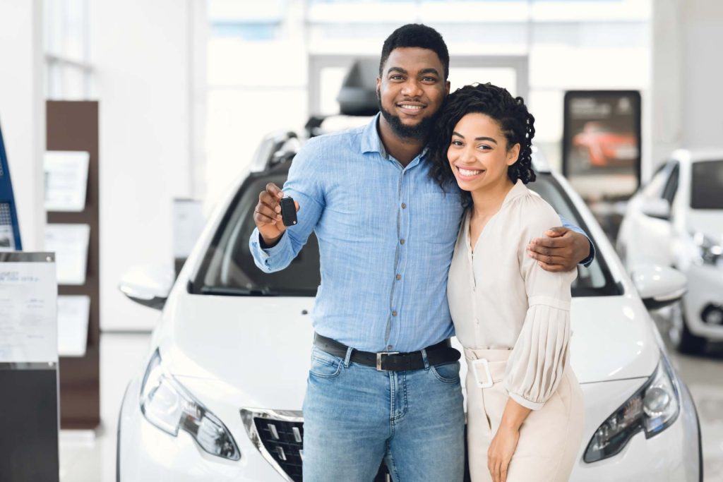 Pareja feliz enseña las llaves de un coche